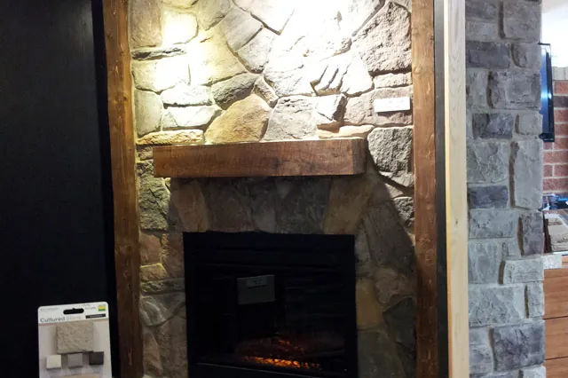 Reclaimed barn beam mantel on a stone fireplace