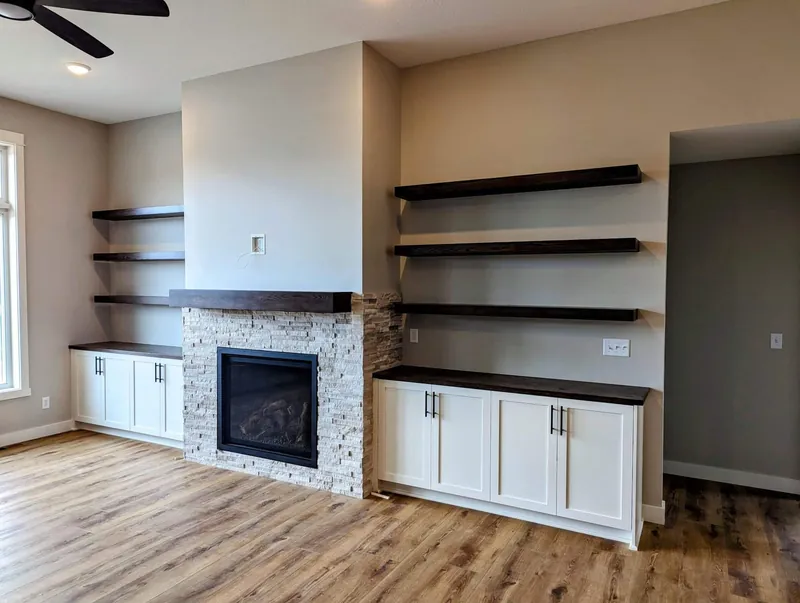 Custom wood mantel with cabinet built-ins beside the fireplace